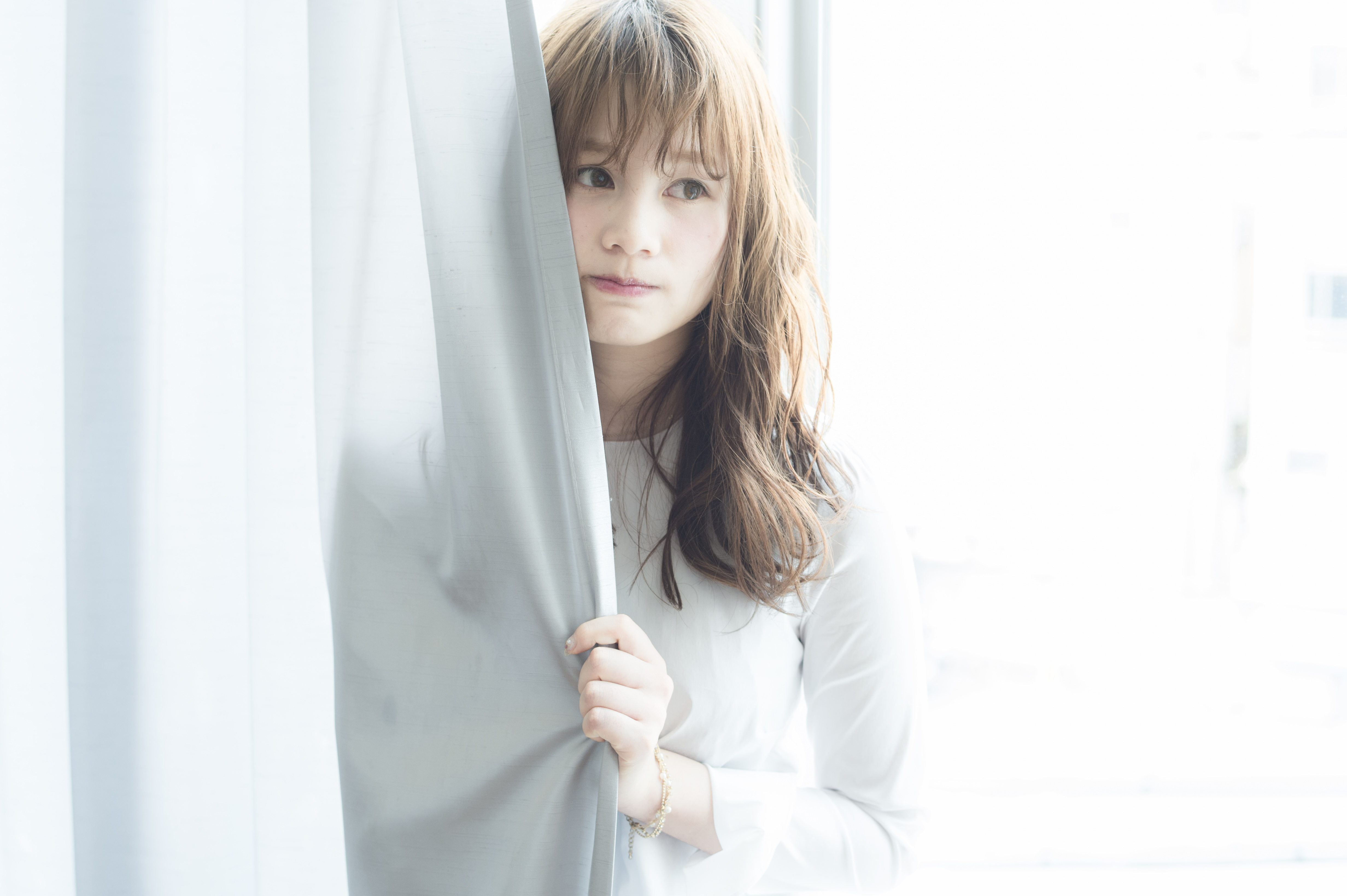 やわらかな光の中でうねりや広がりを自然に整えた髪の女性